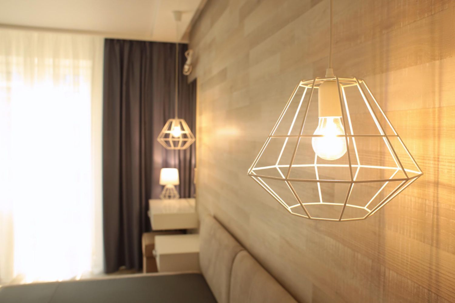 A bedroom with two pendant lights hanging from the ceiling.