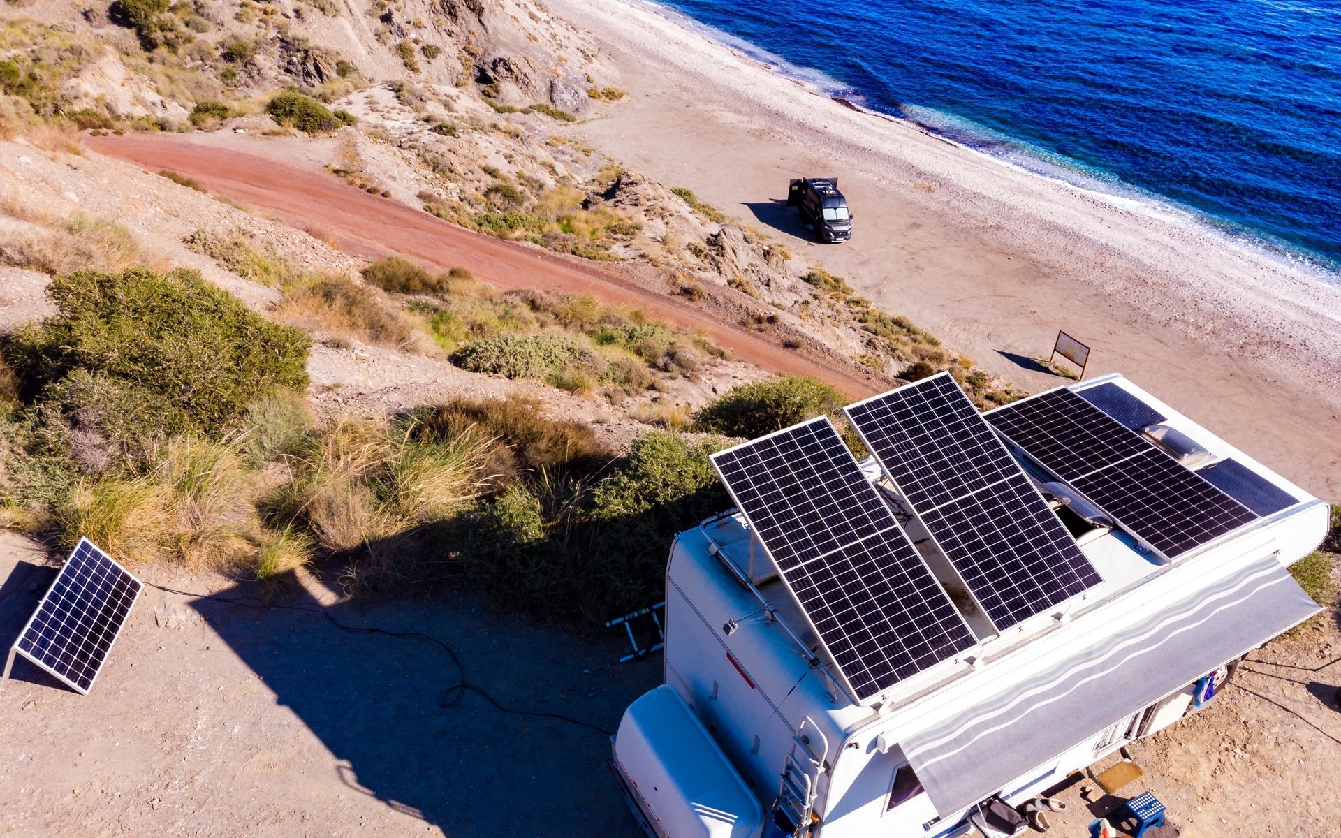 An aerial view of a camper with solar panels on the roof.