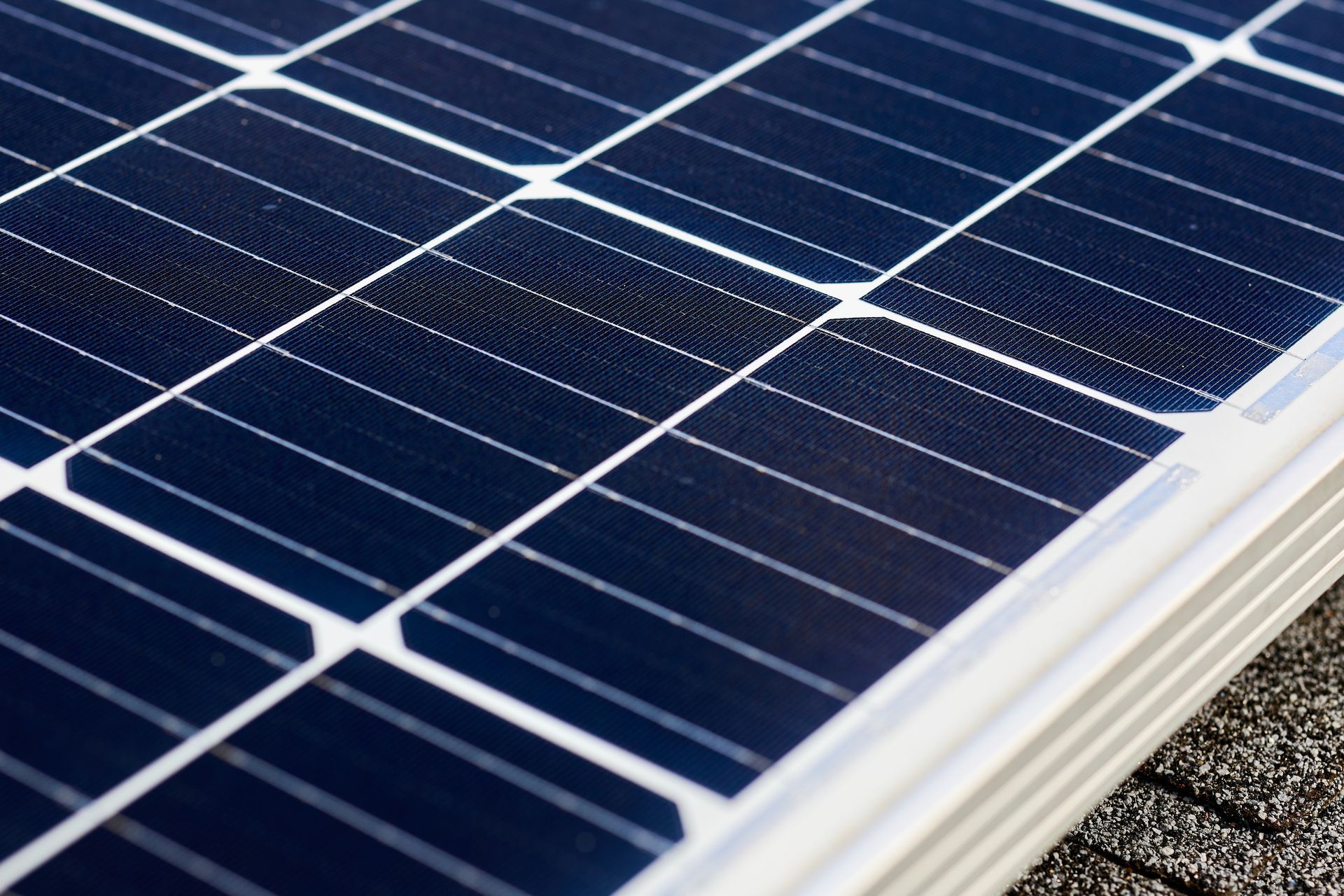 Close-up of blue solar panels with white grid lines on a rooftop