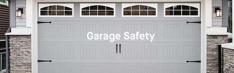 A gray garage door with the words garage safety written on it