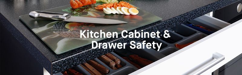 A kitchen cabinet with drawers and a cutting board on top of it.