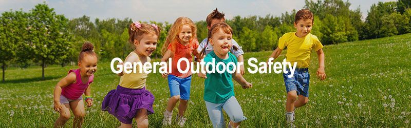 A group of children are running in a grassy field.