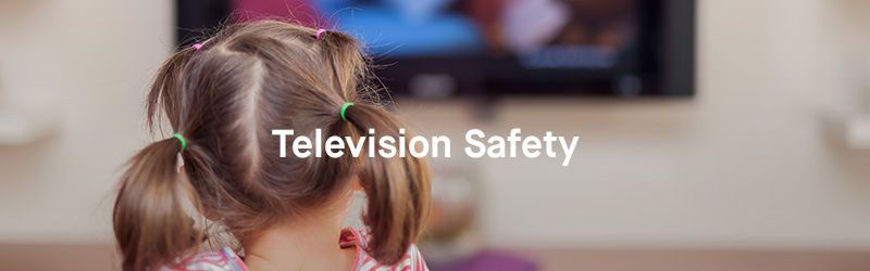 A little girl is sitting in front of a television.