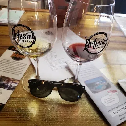 Two glasses of wine and a pair of sunglasses on a table