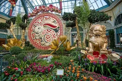 There is a statue of a lion in the middle of a garden.