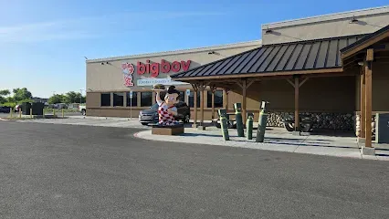 A large building with a black roof and a large statue in front of it.