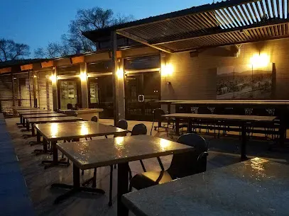 A restaurant with tables and chairs under a canopy at night.