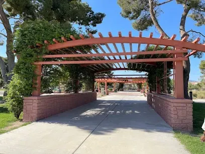 A walkway with a pergola and trees on the side of it