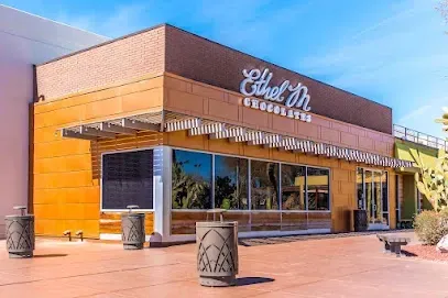 A large building with a lot of windows and a lot of trash cans in front of it.