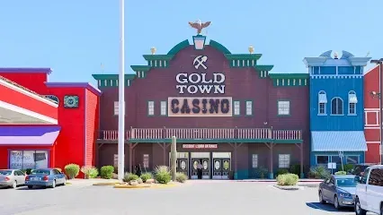 A gold town casino with cars parked in front of it