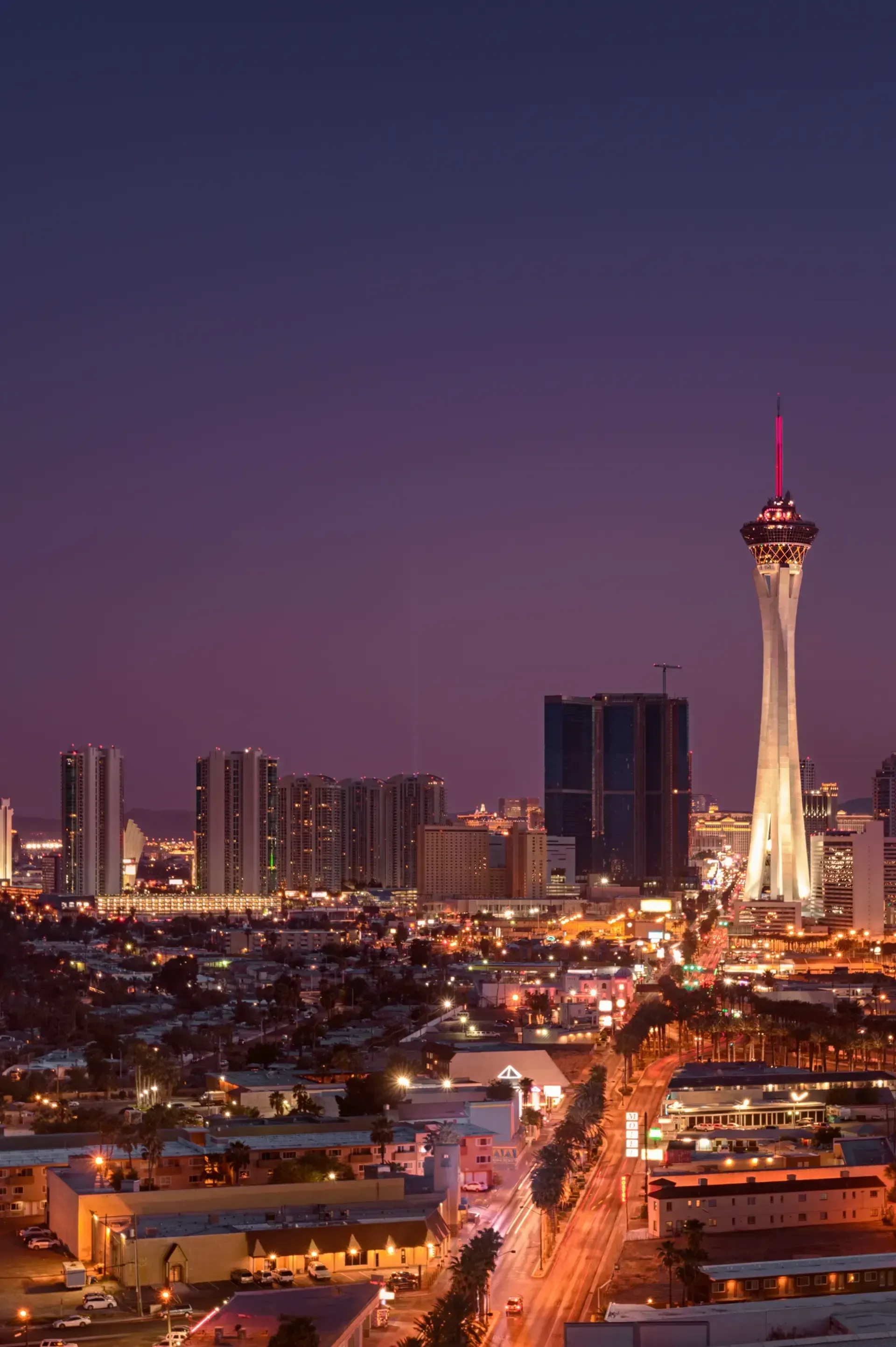 Sell My House Fast - An aerial view of las vegas at night with the stratosphere tower in the foreground.
