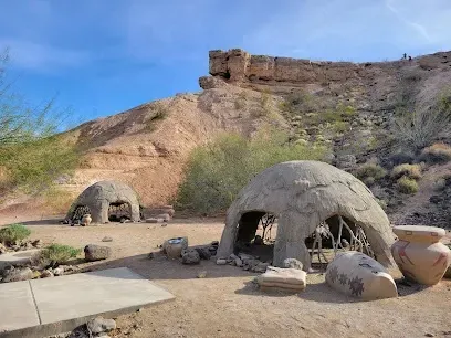 A group of rock sculptures in the desert with a mountain in the background.