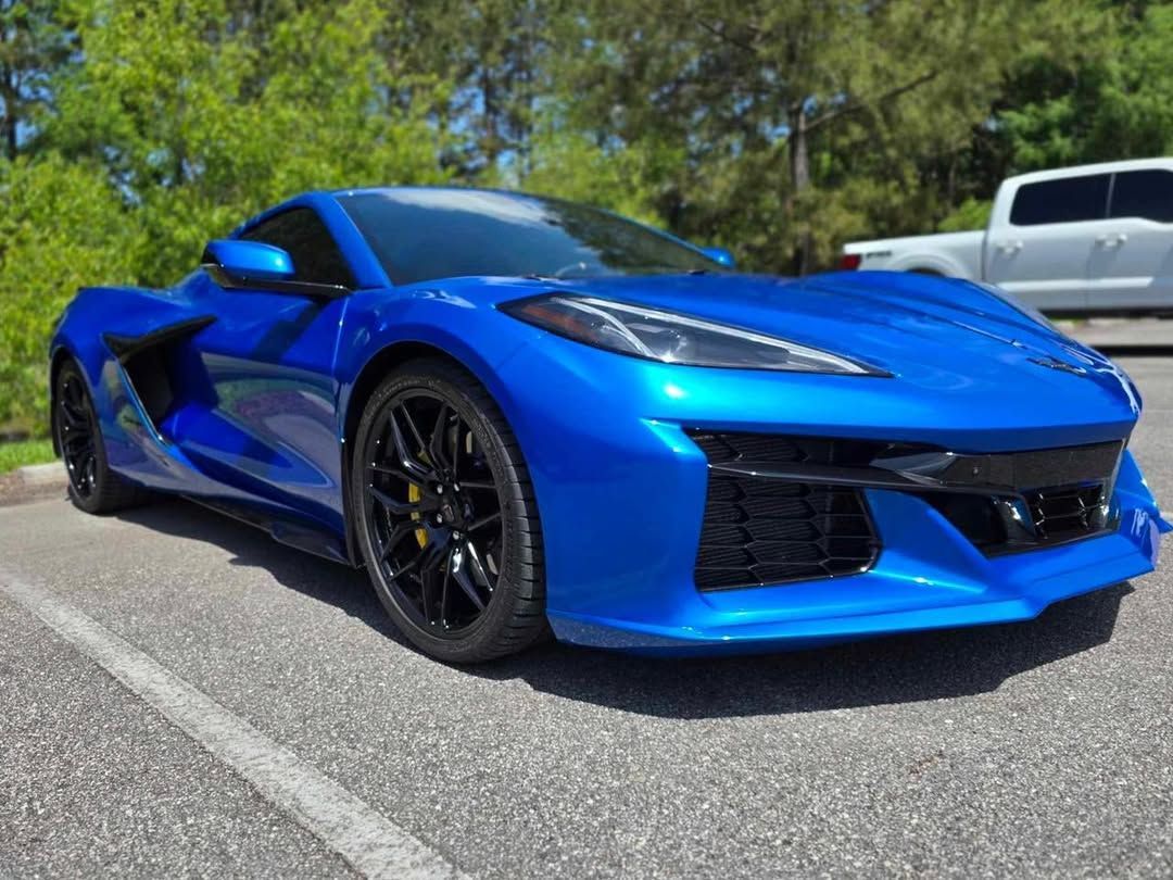 Blue Chevrolet Corvette sports car parked on asphalt.