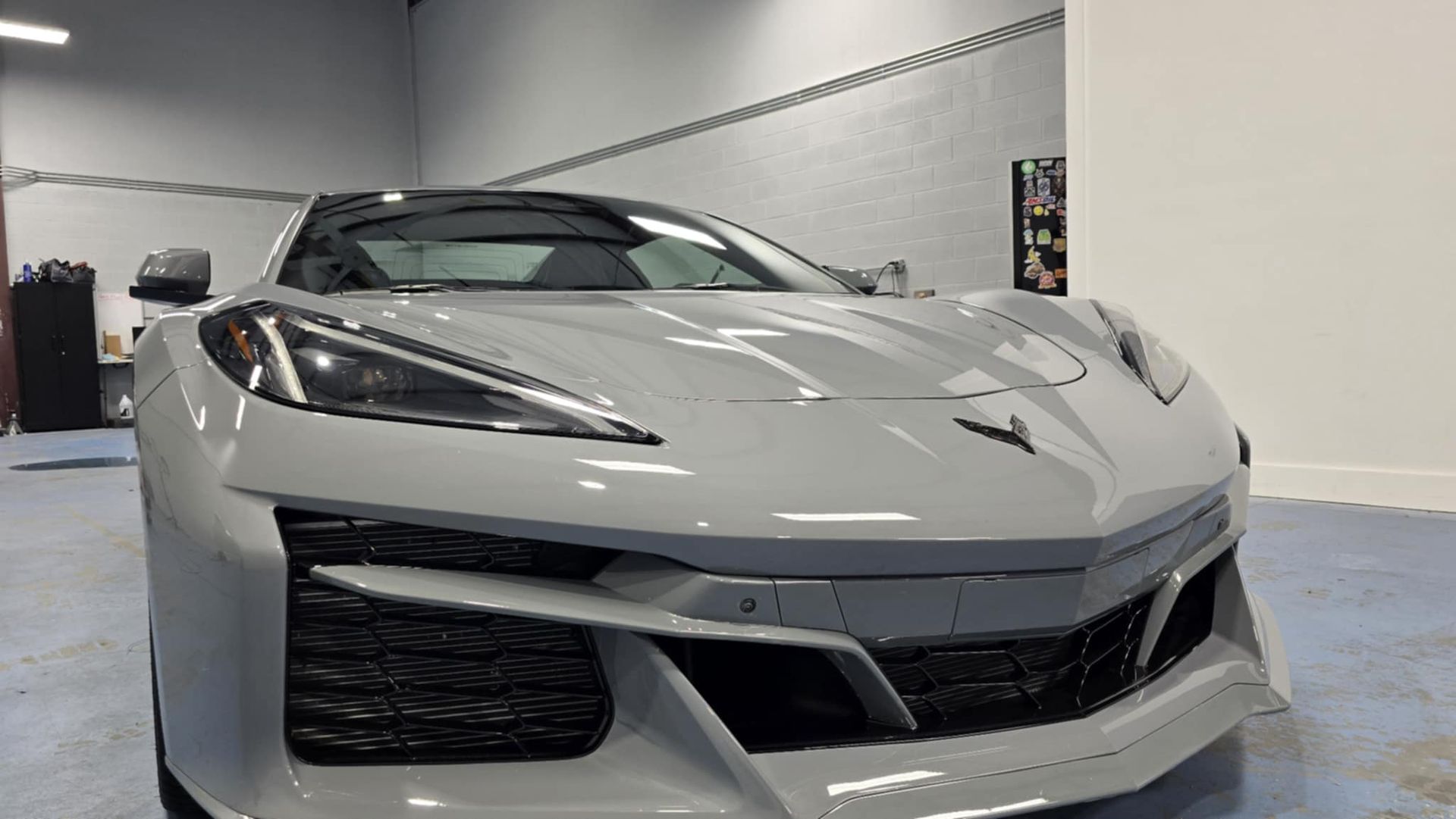 Gray Chevrolet Corvette sports car in a showroom, front view.