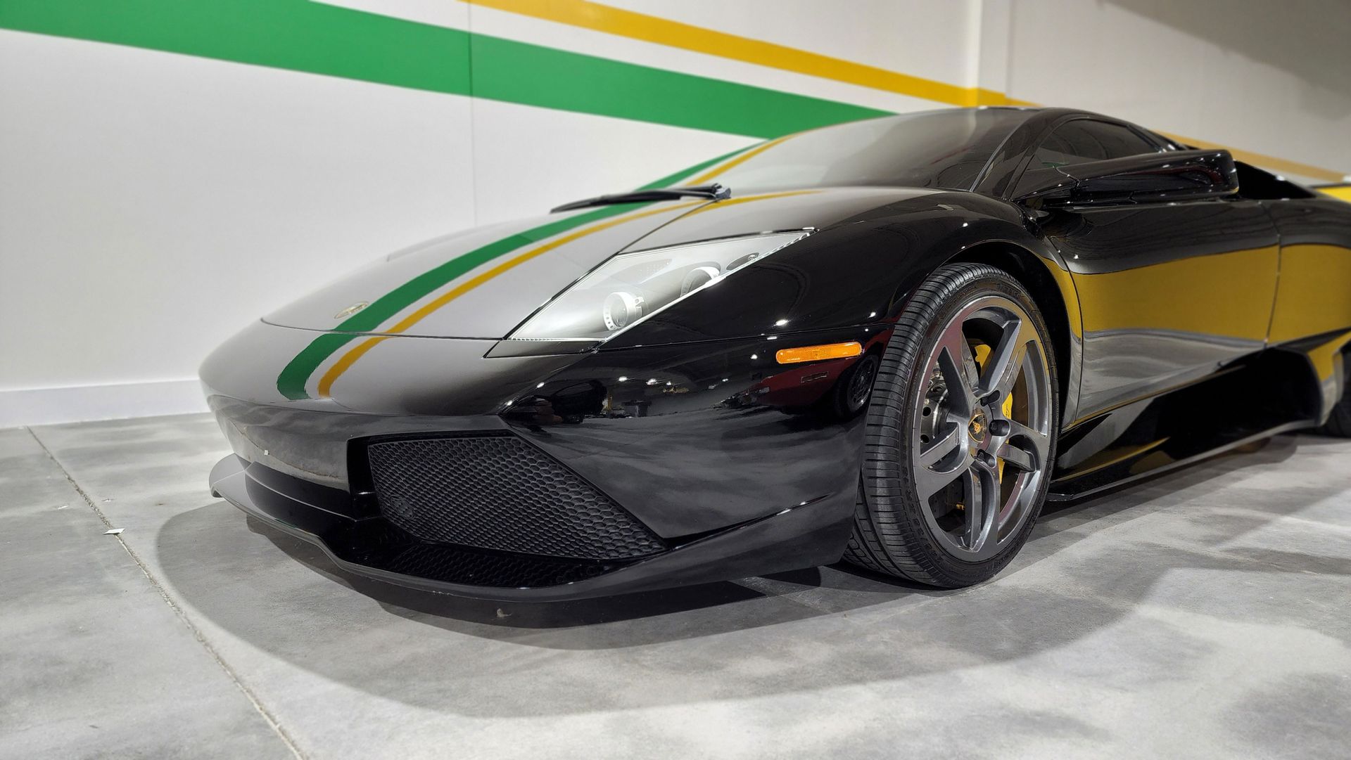 a black sports car with a green and yellow stripe on the side