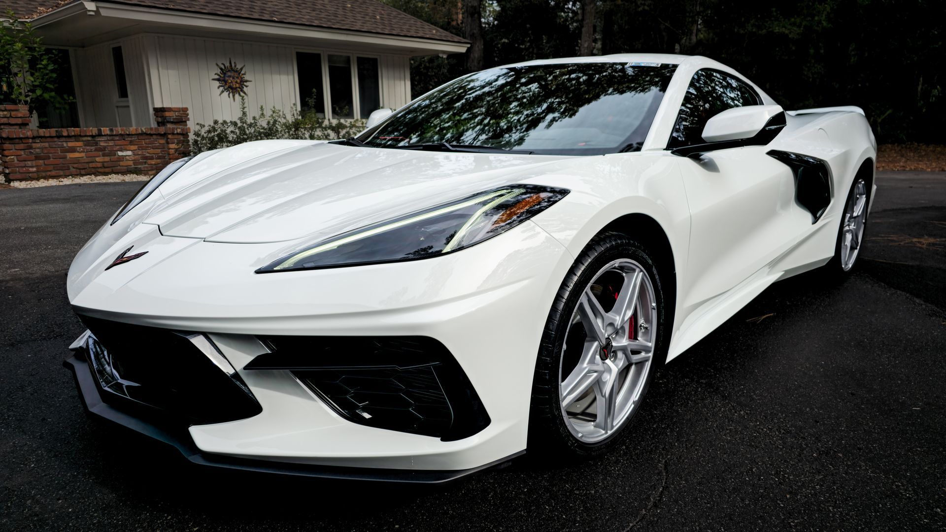 White Chevrolet Corvette sports car parked on asphalt.
