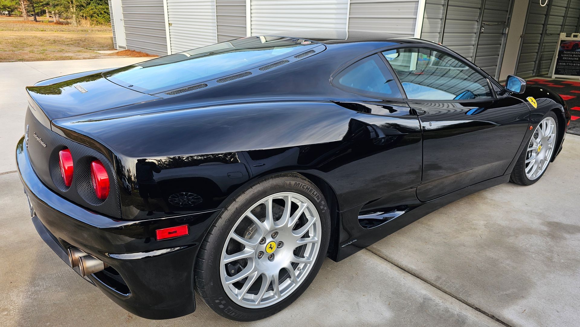 Black Ferrari sports car parked outside.