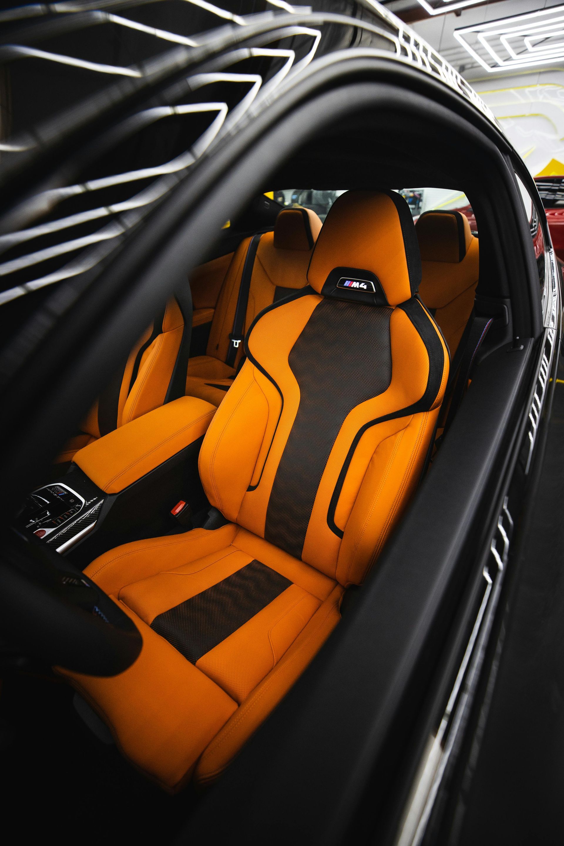 Black car interior with orange and black racing seats.