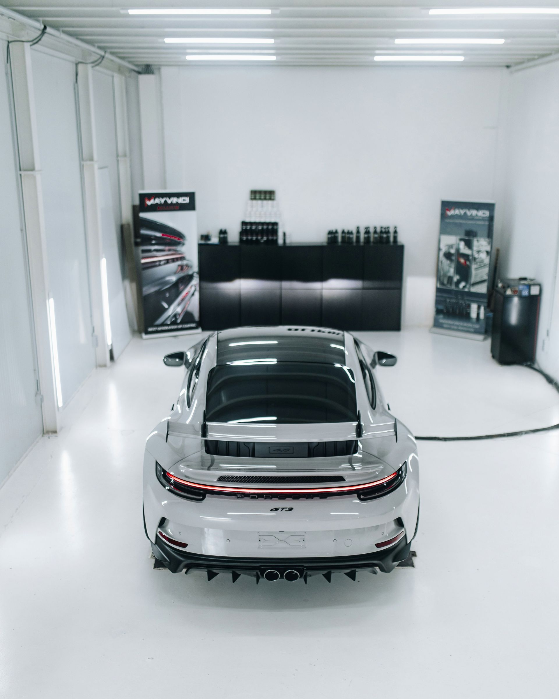 Red BMW M4 coupe parked inside a garage, showcasing its rear end.