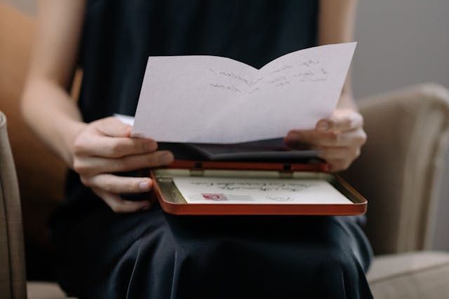 A person holding a letter over a keepsake box with cremation services in Burnsville, MN