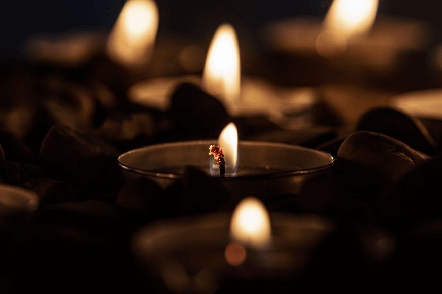 Candlelight glowing among smooth stones creates a peaceful scene for cremation services Chaska, MN