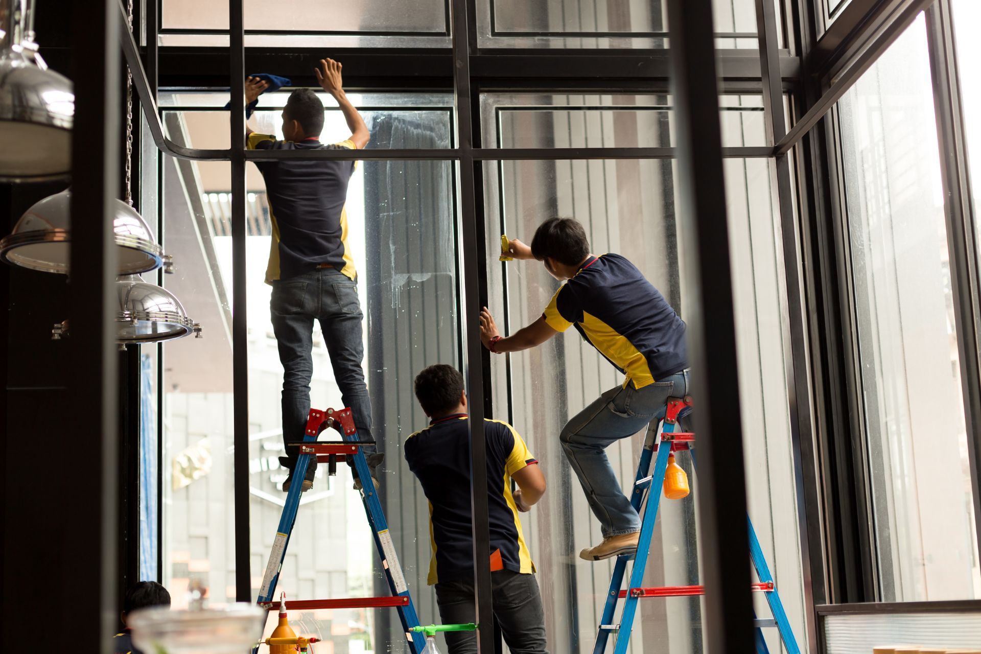 Techs installing window tint on building