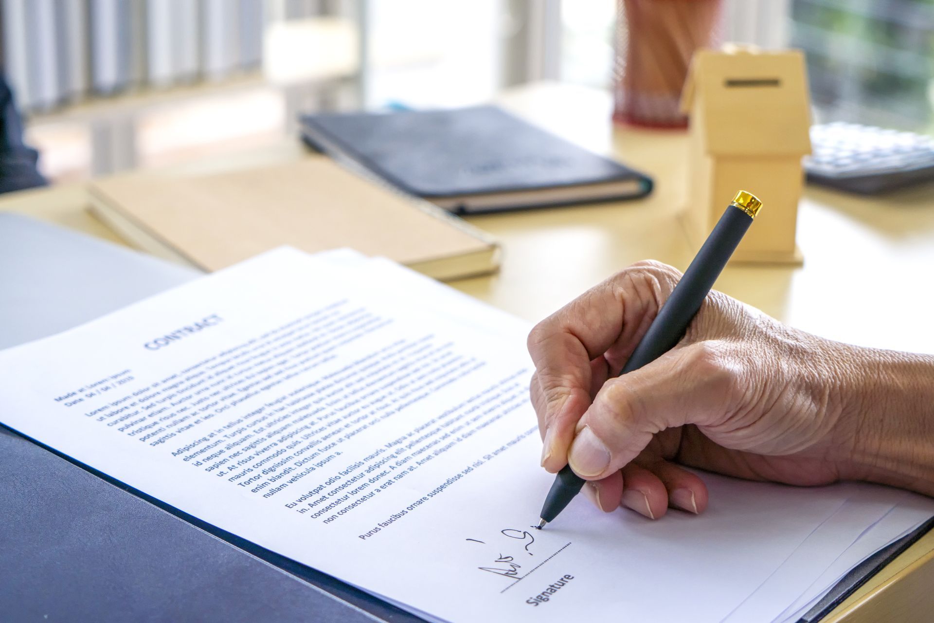 A person is writing on a piece of paper with a pen.