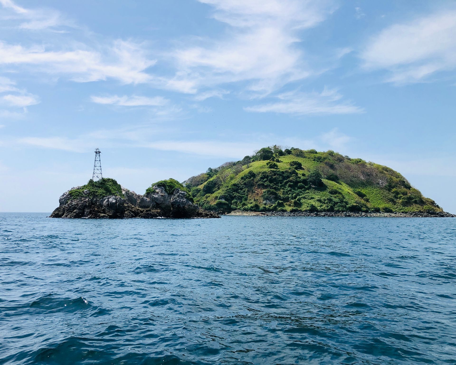 City skyline from the water, with white buildings against a blue sky and water.