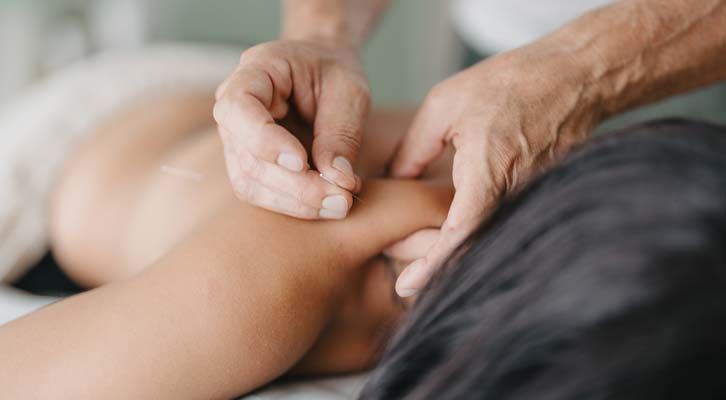 An acupuncturist inserting needles into a patient's neck, representing Neck Pain Relief NYC by Marc Bystock L.Ac.