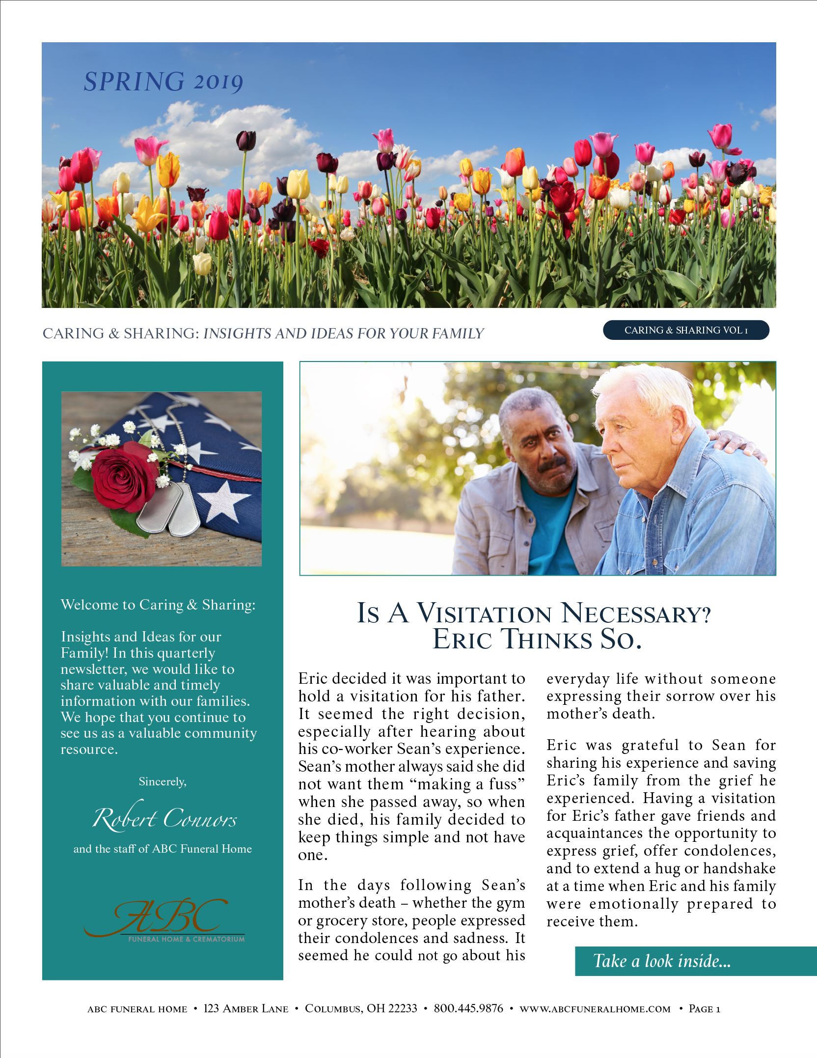A couple of men standing next to each other in front of a field of flowers.