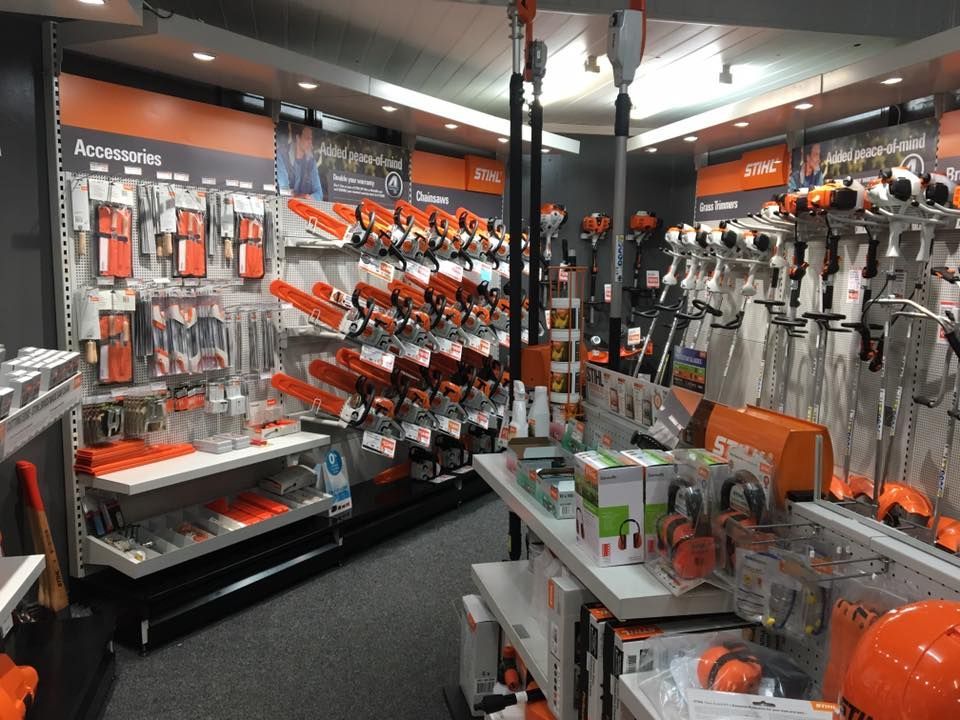 A retail store interior with Stihl brand chainsaws, accessories, and tools on display.