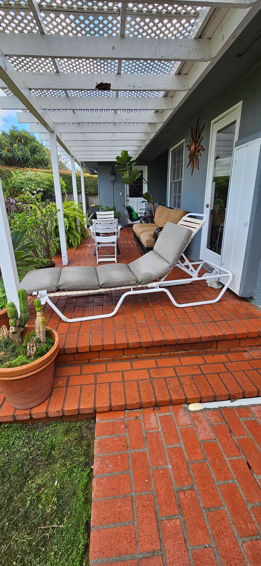 There are a lot of chairs on the porch of a house.