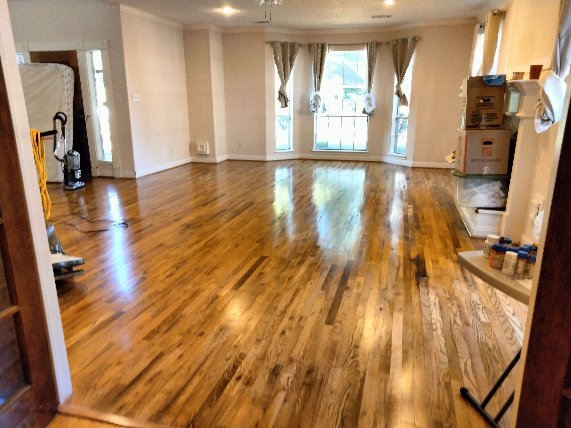 A living room with hardwood floors and white walls.