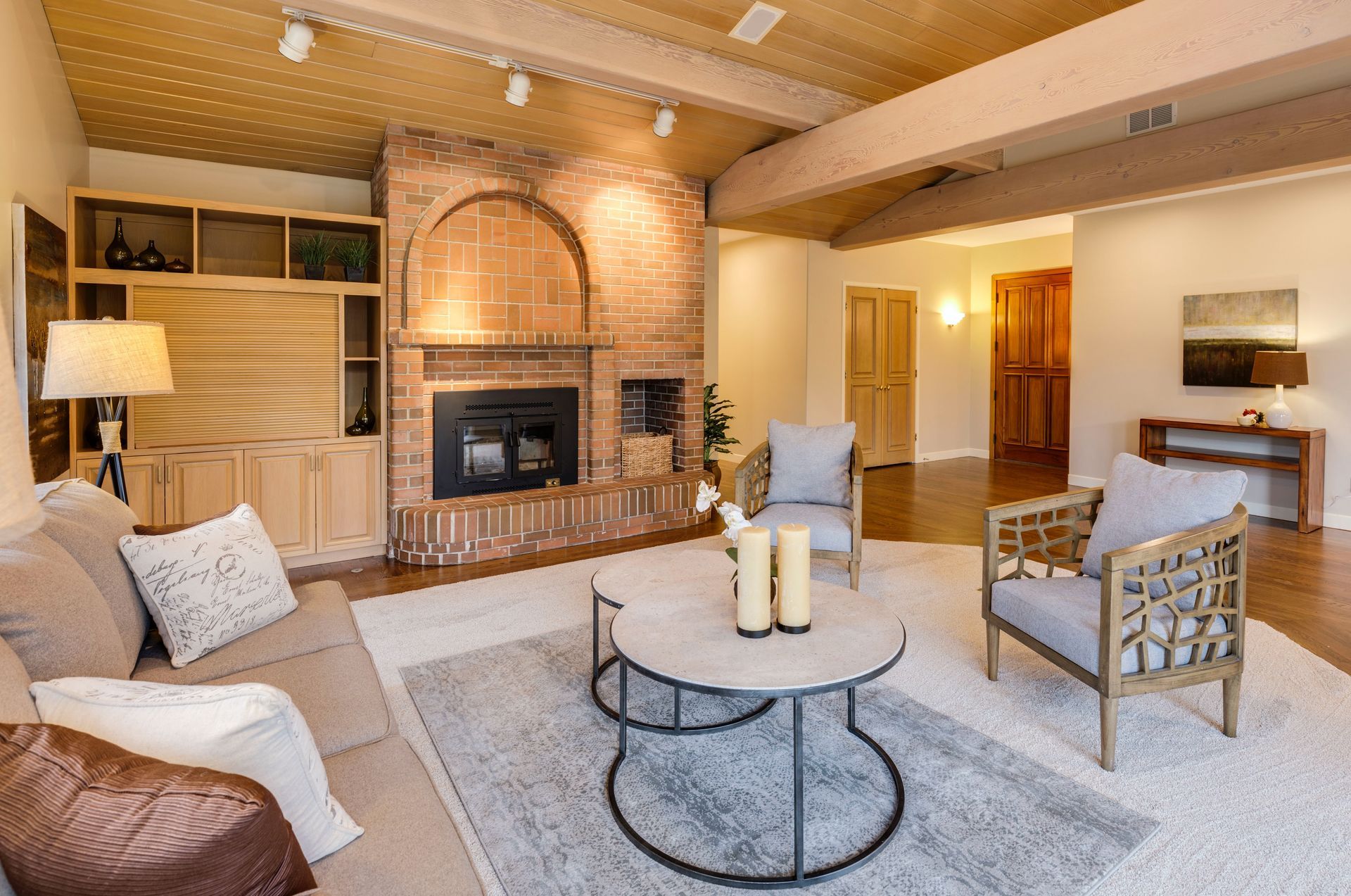 A living room with a couch , chairs , coffee table and fireplace.