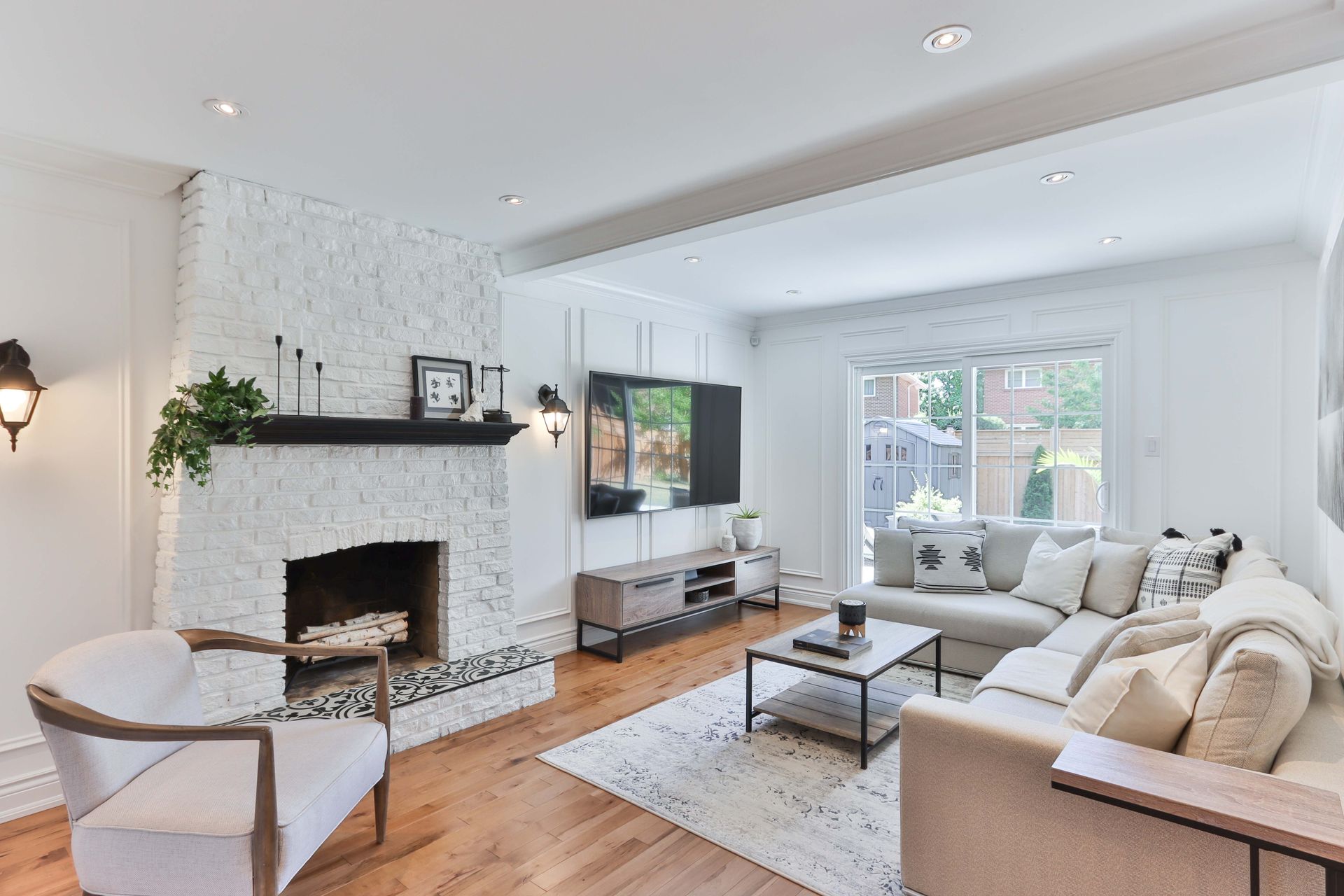 A living room with a couch , chair , fireplace and television.