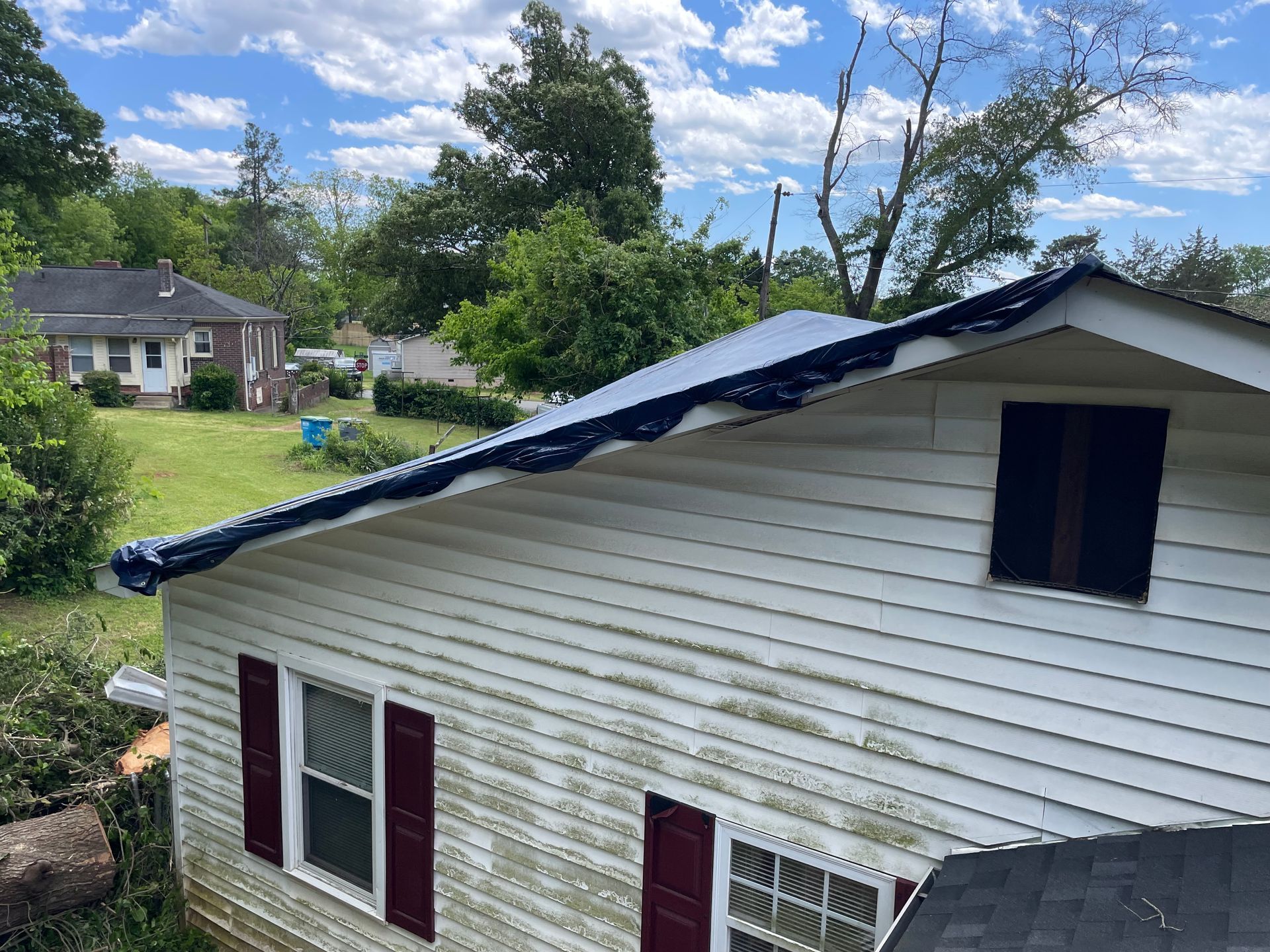 A white house with a blue roof and red shutters.