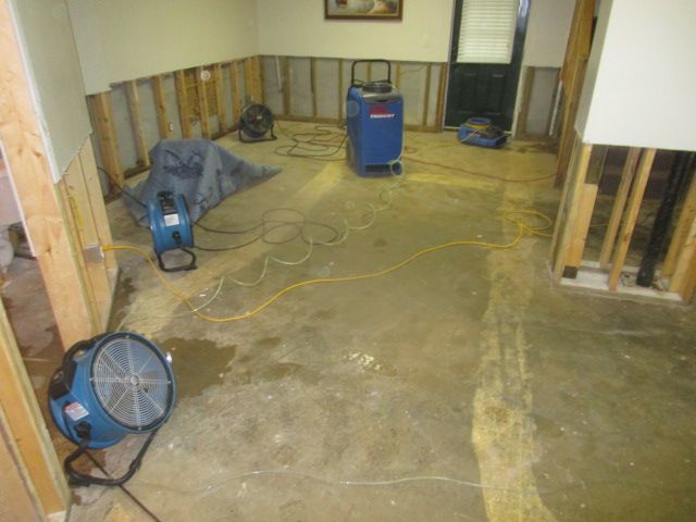 A room with a fan and a machine on the floor