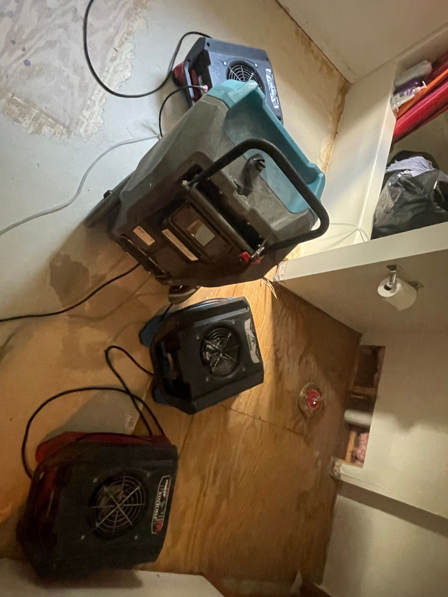 A couple of fans sitting on top of a wooden floor in a room.