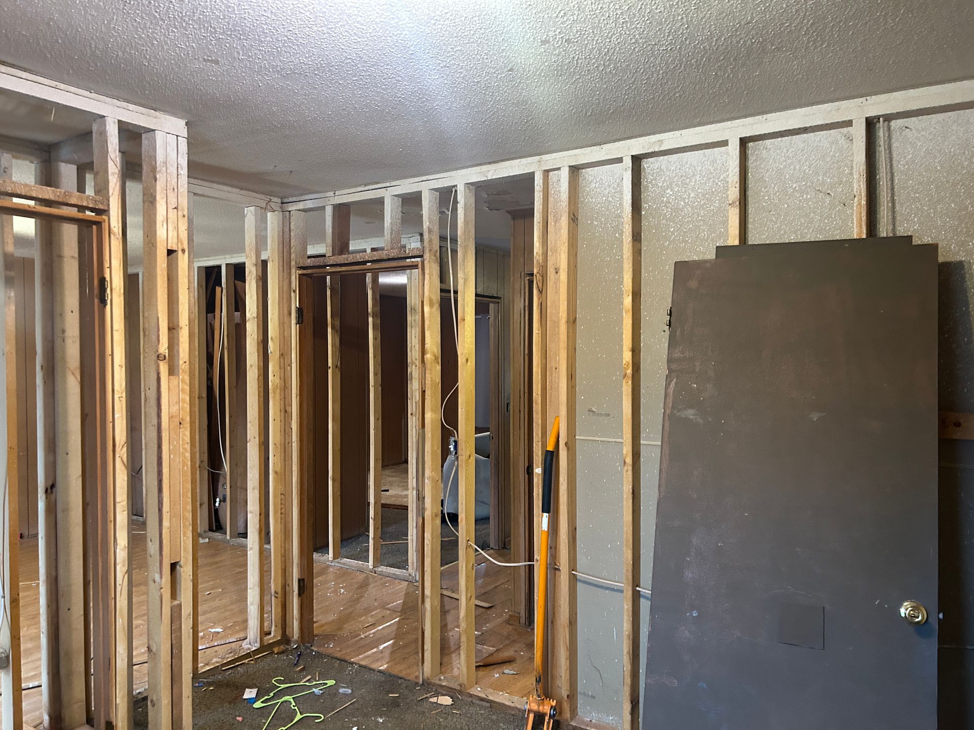 A room that is being remodeled with wooden walls and a door.