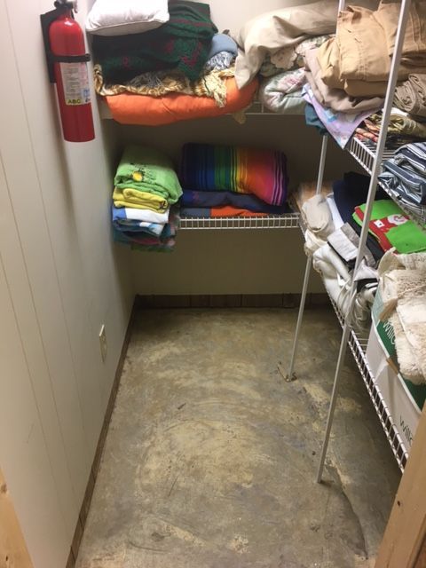 A closet filled with clothes and a fire extinguisher