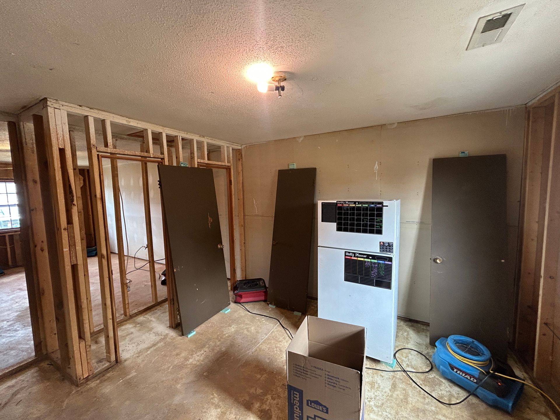 A room that is being remodeled with a refrigerator and stove.