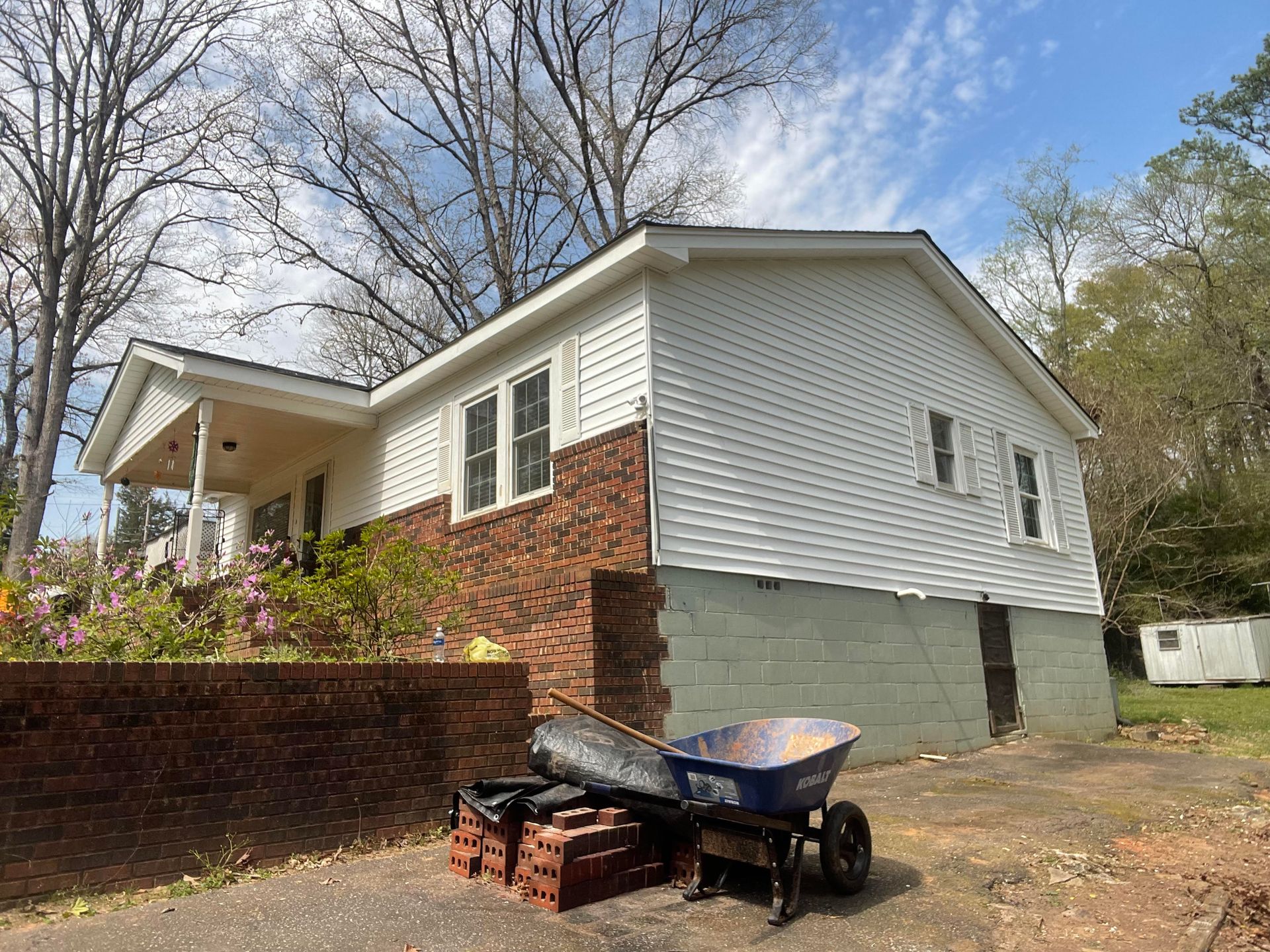 A house with a wheelbarrow in front of it.
