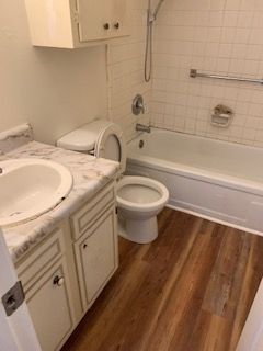 A bathroom with a toilet , sink , bathtub and shower.