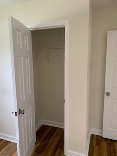 There is a closet in the corner of the room with a door open.