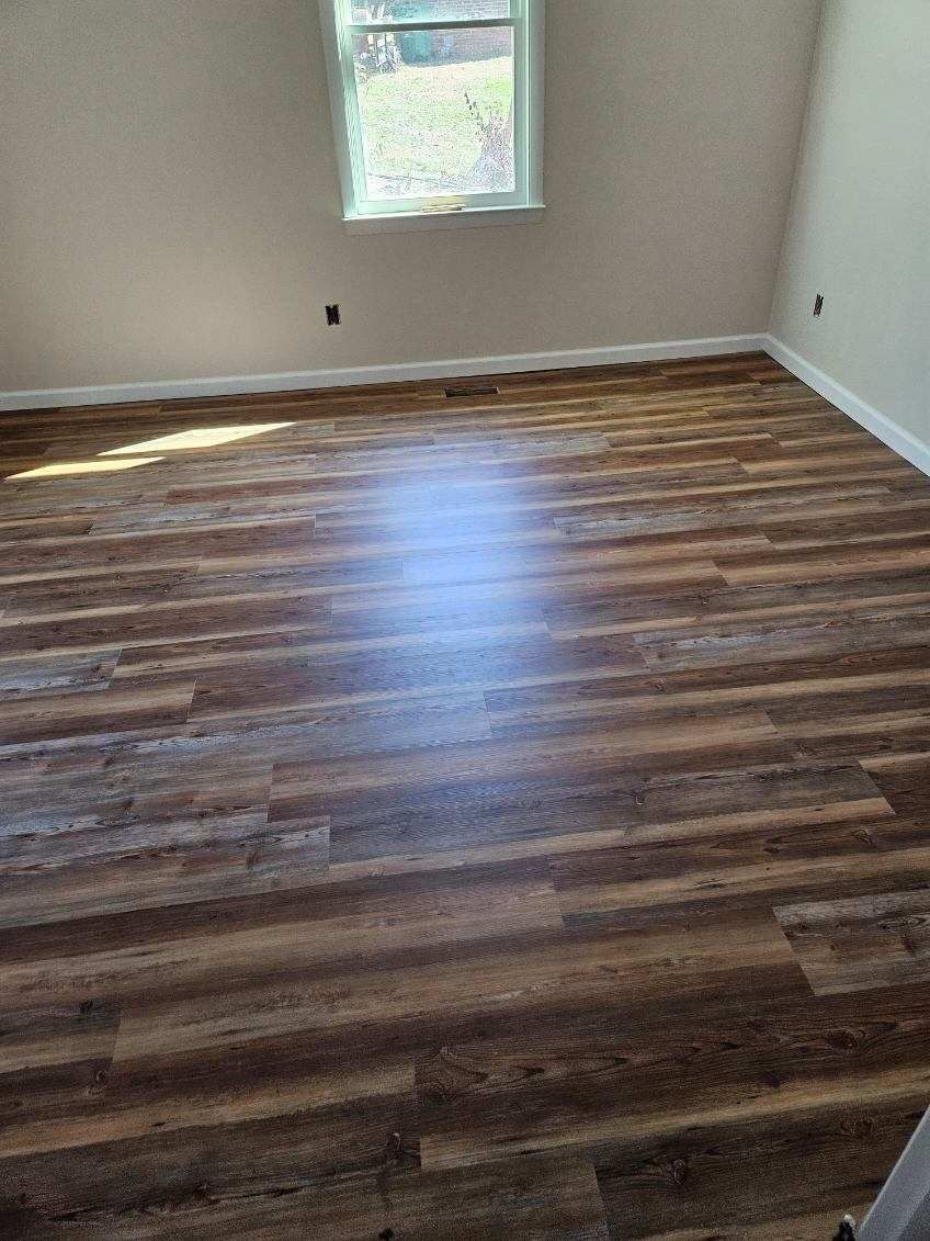 A room with a wooden floor and a window.