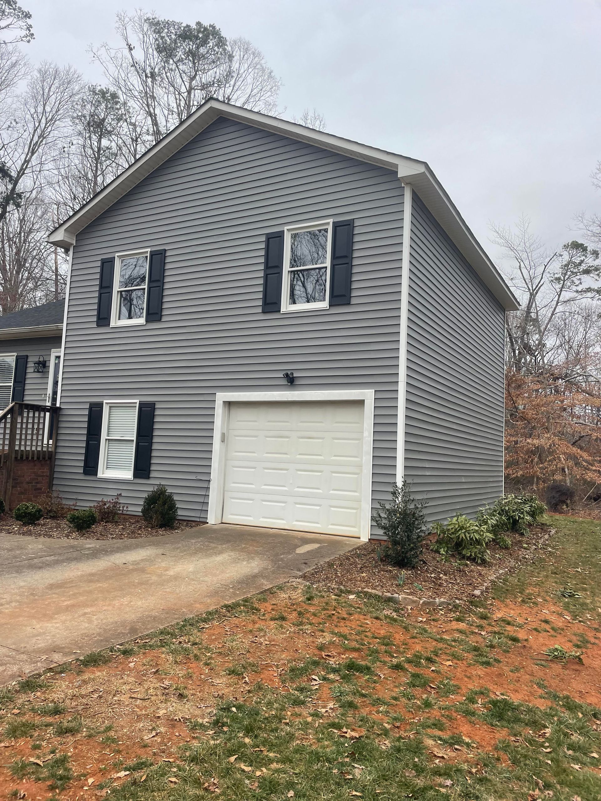 A house with a garage and a driveway in front of it.