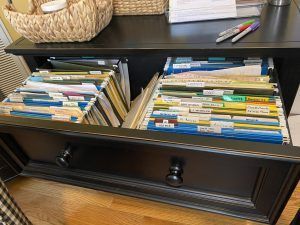 A black dresser with a drawer filled with folders and papers.