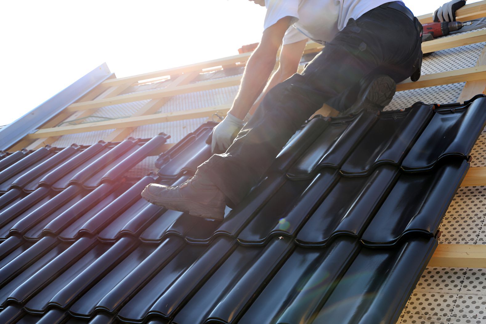 A Man is Working on the Roof of a Building — Goonellabah Roof Tilers in Mullumbimby, NSW