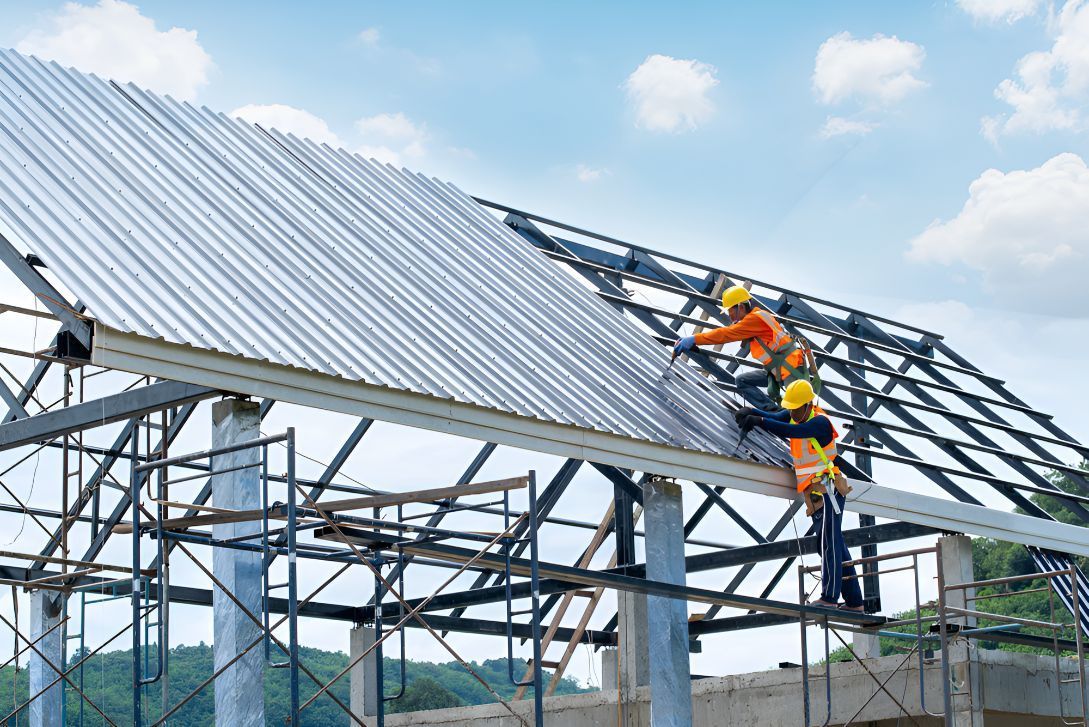 A Group of Construction Workers Are Working on the Roof of a Building — Goonellabah Roof Tilers in Lennox Head, NSW