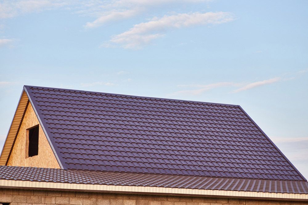 Roof of The House Covered with Burgundy Metal Tile — Goonellabah Roof Tilers In Byron Bay, NSW